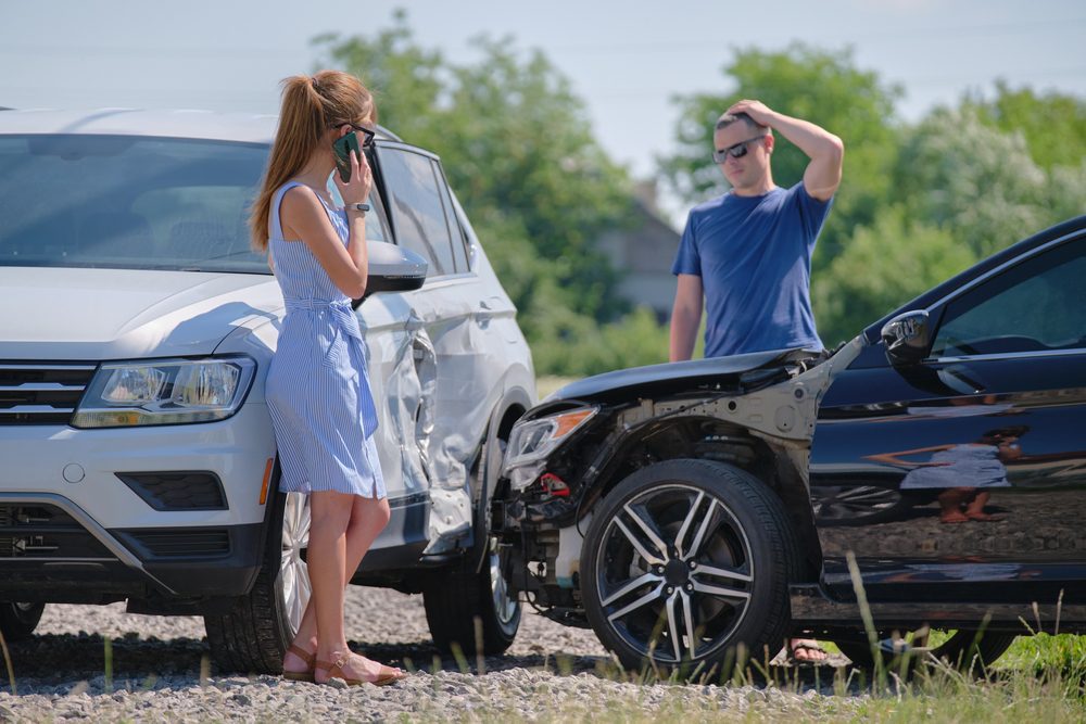 an-someone-sue-you-for-a-car-accident-if-you-have-insurance? Alt text: A woman standing outside of a car crash wonders, “Can someone sue you for a car accident if you have insurance?”