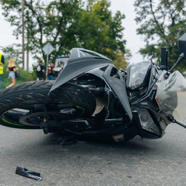 A crashed motorcycle lies in the road. Does health insurance cover motorcycle accident injuries?