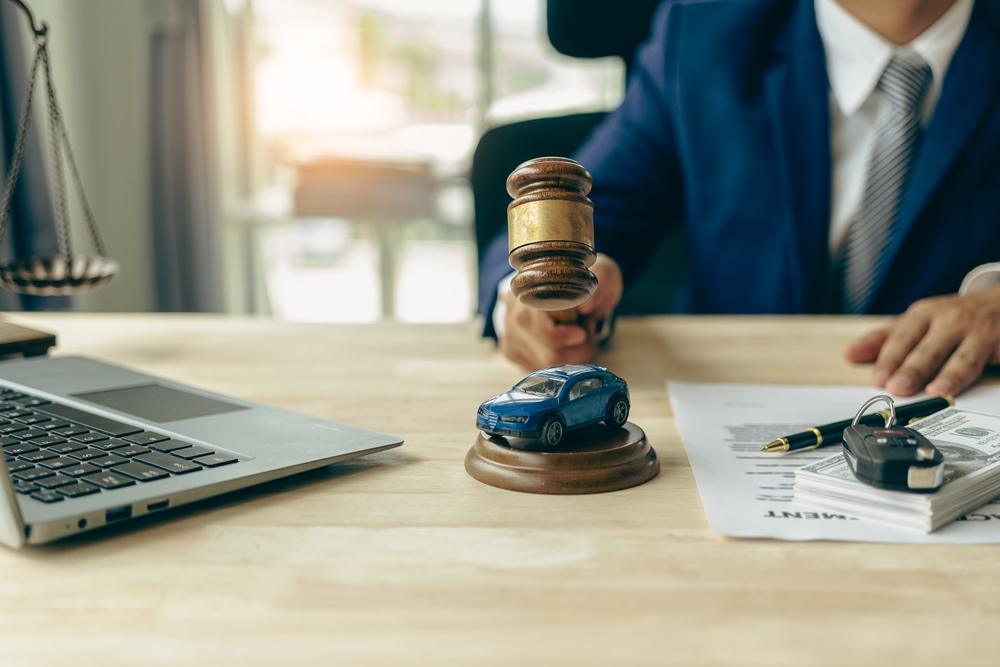 A toy car is on the desk of a personal injury attorney next to a gavel, symbolizing the question of whether you can sue Uber for an accident.