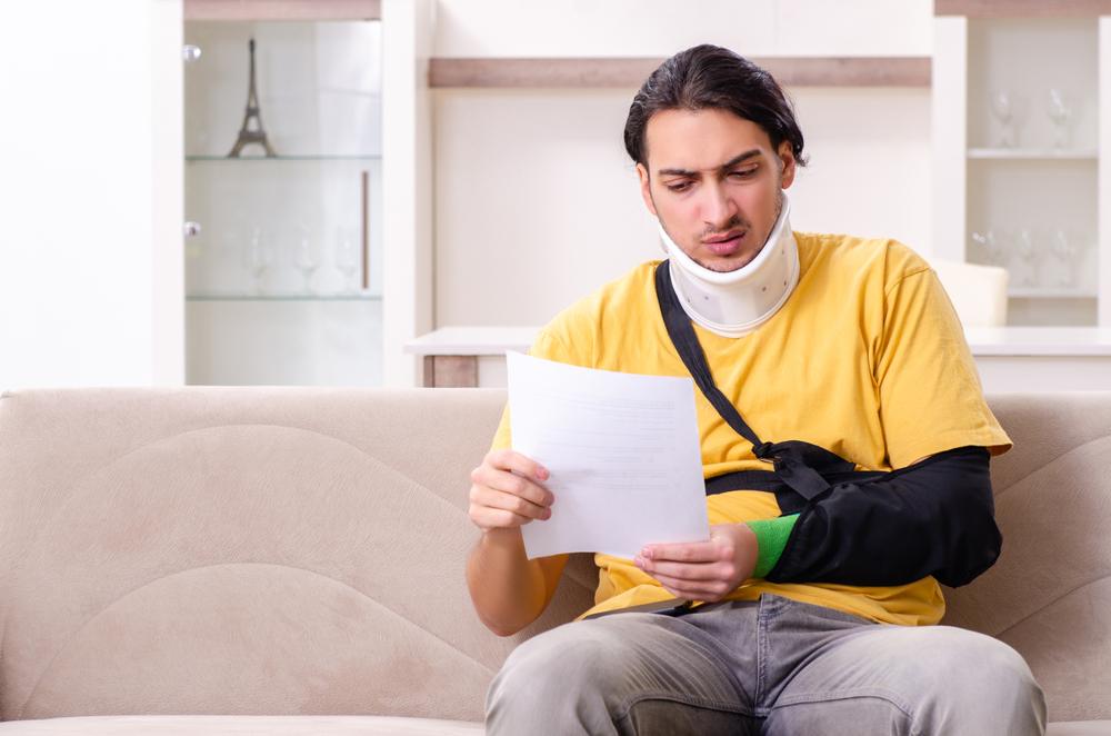 An injured man looks at an invoice and wonders how medical bills are paid after a car accident. 