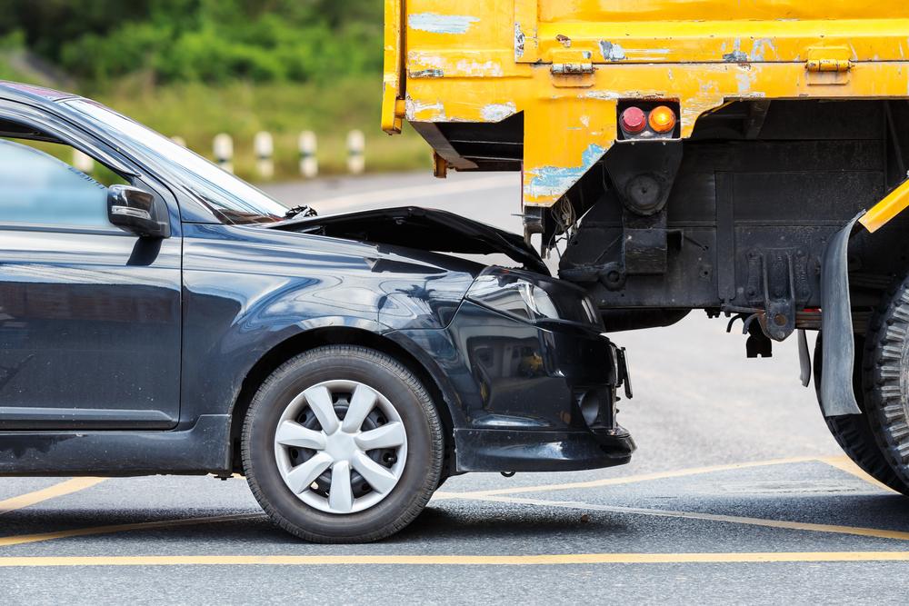 A car and truck in the aftermath of a crash, while the car owner wonders how to choose a truck accident lawyer.