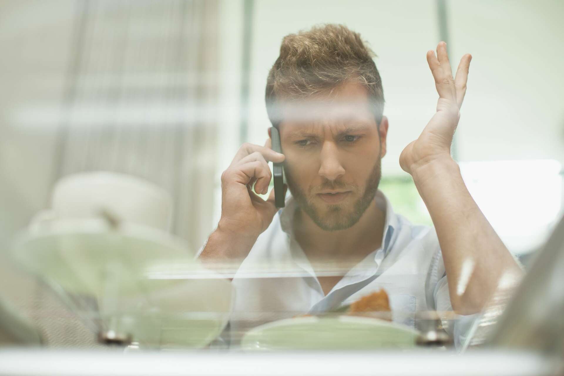 A frustrated man talking on the phone. Learn about how you negotiate a truck accident settlement.