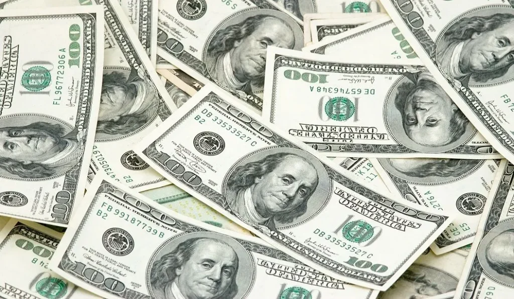 A pile of money indicating how much you can sue someone for a car accident in Kansas City.