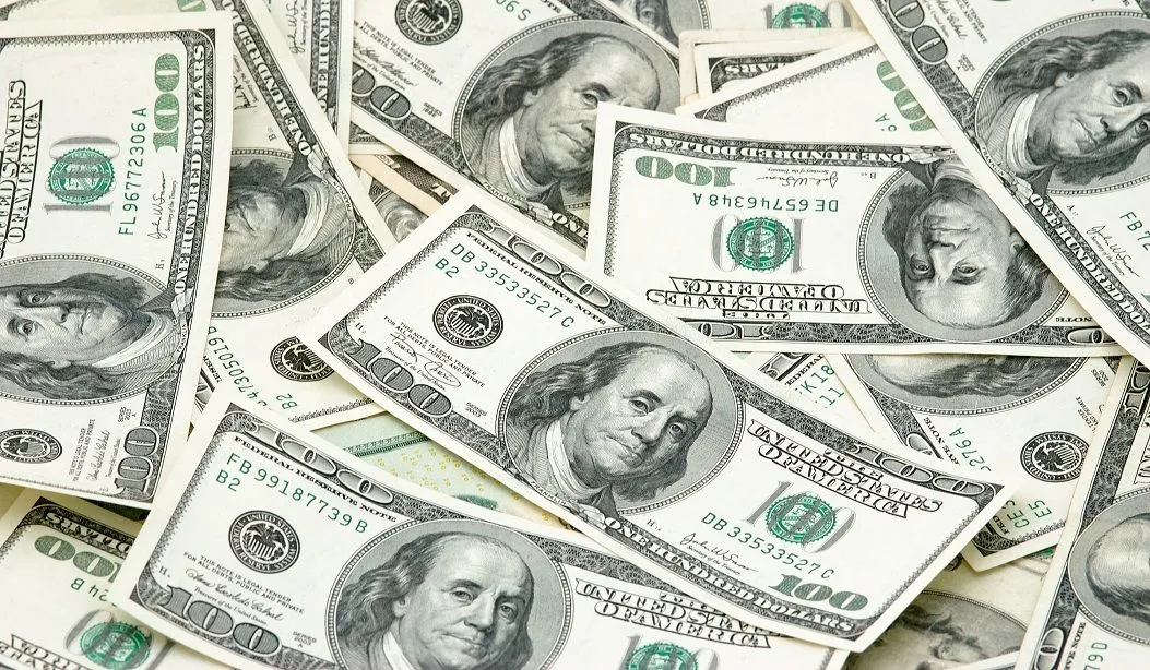 A pile of money indicating how much you can sue someone for a car accident in Kansas City.