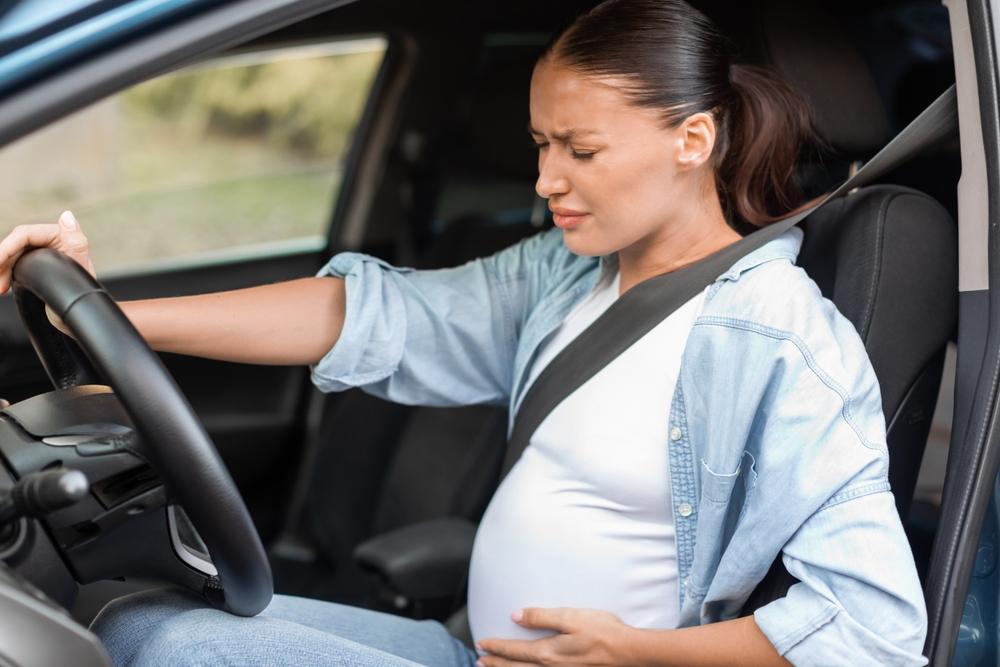 A pregnant woman behind the wheel of a car wonders about the average settlement for pregnant car accident victims. 