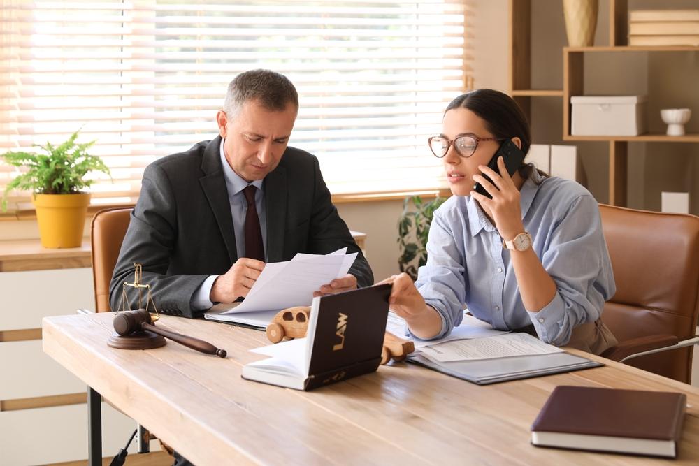 An attorney calls her client and lets them know whose insurance pays in a multi-car accident.
